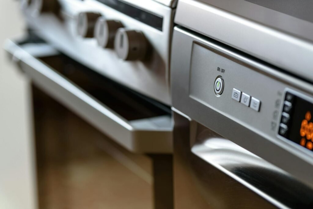 Close-up view of modern stainless steel kitchen appliances with focus on dishwasher and oven.