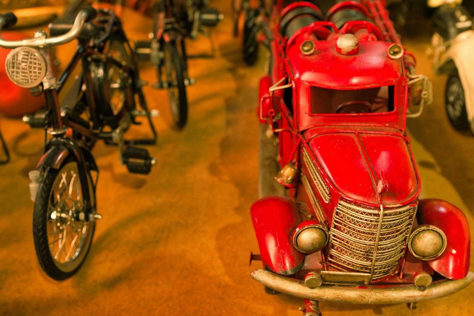 A red toy car sitting on top of a wooden floor