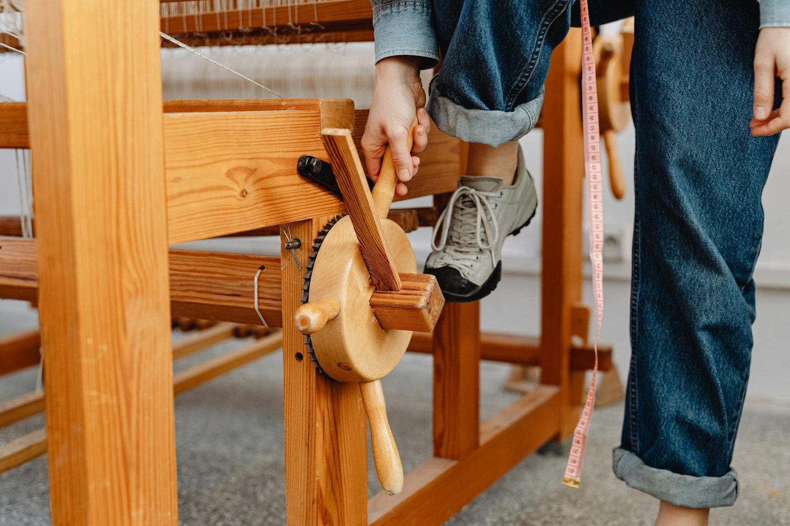 person in jeans using wooden weaving machine, Weaving Spinning Wheels